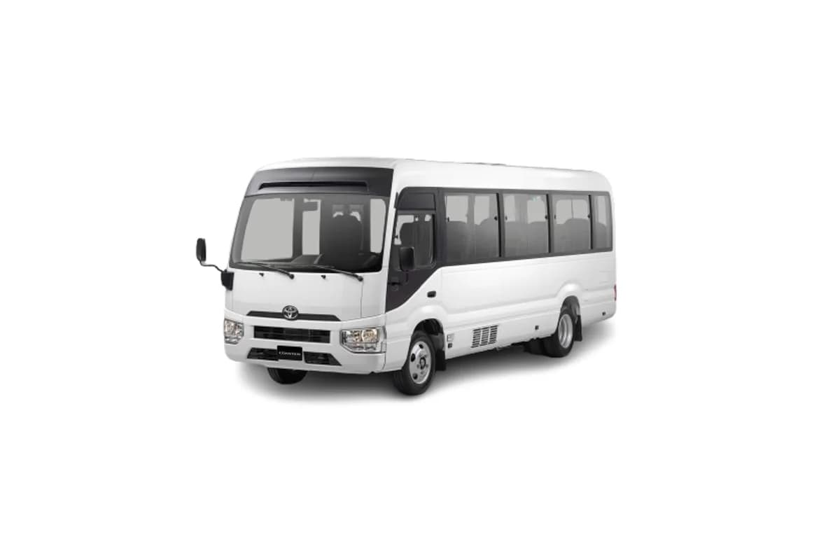 White Toyota Coaster mini bus for large Umrah group transport in Saudi Arabia